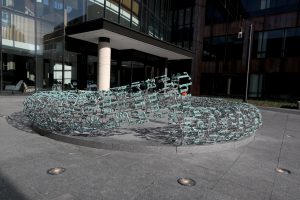 Side view of Broken English by Gregory Gomez with Grinnell's Humanities and Social Sciences Center in background HSSC)